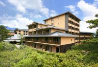 a large building on top of a hill with trees at Tokinoniwa in Kusatsu