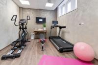 a room with a gym with a treadmill and a exercise ball at Campanile Epinal Centre - Gare in Épinal