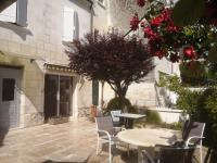 a patio with a table and chairs next to a building at Jolie maison atypique à Montrichard in Montrichard