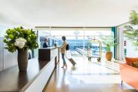 a woman standing at a counter in an airport lobby at Sleep&amp;Fly in El Prat de Llobregat