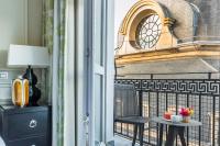 a balcony with a table and a clock tower at Grand Hôtel Du Palais Royal in Paris