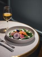 un plato de ensalada en una mesa con una copa de vino en Dandy Hotel & Kitchen, en París