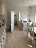 a kitchen with a table and a door to a room at appartement spacieux et lumineux proche de la plage in Quimiac