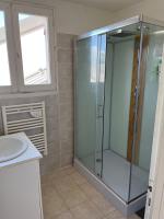 a bathroom with a glass shower and a sink at appartement spacieux et lumineux proche de la plage in Quimiac