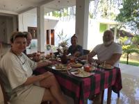 ティッサマハーラーマにあるElegant Lake Yala Safari Houseの食卓に座って食べ物を食べる男たち