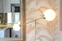 a floor lamp in front of a wall with a mirror at Le Lac d&#39;Or - Duke Housing in Créteil