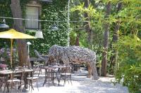a statue of a giraffe standing next to tables and chairs at Hostellerie Le Paradou in Lourmarin