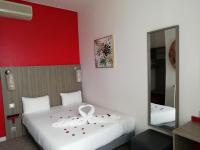 1 dormitorio con cama blanca y pared roja en Hôtel de Champagne, en Angers