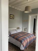 a bedroom with a bed with a plaid blanket at Suite&amp;Caux 1 in Cany-Barville