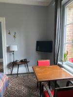 a living room with a table and a tv at Suite&amp;Caux 1 in Cany-Barville
