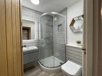 a bathroom with a shower and a toilet and a sink at Westward 14 Polzeath in Polzeath