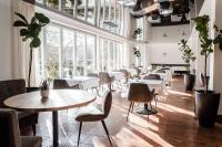 a restaurant with tables and chairs and large windows at Hotel Antoniushof in Ruhstorf