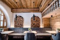 a restaurant with wooden ceilings and tables and logs at Hotel Antoniushof in Ruhstorf