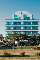 un gran edificio azul con árboles delante de él en Apart Hotel Punta Azul, en Punta del Este