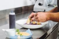 a person preparing a bowl of food on a counter at Exclusive Boutique Hotel Elisabetta in Ronco s/Ascona - Porto Ronco