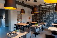 a restaurant with wooden tables and chairs and a black wall at Qbatura Cafe & Hotel in Ciechanów