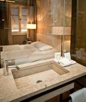 a bathroom with a sink with a bed in the background at CORTIINA Hotel in Munich