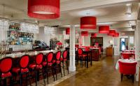 a restaurant with red chairs and a bar at Camden Harbour Inn a member of Small Luxury Hotels in Camden