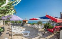 a group of chairs and umbrellas on a patio at Gorgeous Apartment In Vir With House Sea View in Vir