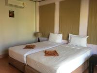a large white bed with two brown towels on it at Gooddays Lanta Beach Resort SHA in Ko Lanta