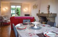 a dining room with a table and a fireplace at Stunning Home In Kerbors With House Sea View in Kerbors
