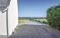 a gravel driveway next to a white building with a field at Stunning Home In Kerbors With House Sea View in Kerbors
