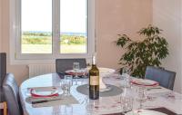 a dining table with a bottle of wine on it at Stunning Home In Kerbors With House Sea View in Kerbors