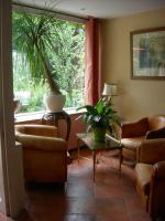a living room with a plant on a table and a window at Cit&#39;Hotel Avallon Vauban in Avallon
