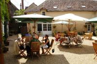 a group of people sitting at tables under umbrellas at Le Relais du Lyon d&#39;Or in Angles-sur-lʼAnglin