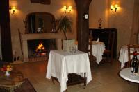 a living room with a fireplace and a table with a table cloth at Le Relais du Lyon d&#39;Or in Angles-sur-lʼAnglin