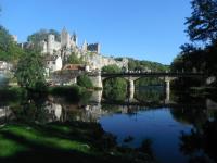 a bridge over a river with a castle in the background at Le Relais du Lyon d&#39;Or in Angles-sur-lʼAnglin
