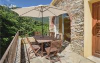 a wooden table and chairs with an umbrella on a balcony at Cozy Home In Santa Maria Poggio With House A Mountain View in Santa-Maria-Poggio