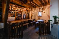 Un restaurante con mesas y sillas de madera y lámparas de araña. en Hotel Cornelyshaff, en Heinerscheid