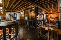 Un restaurante con suelos de madera, mesas y sillas. en Hotel Cornelyshaff, en Heinerscheid