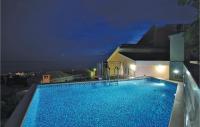 a swimming pool on the side of a building at night at Cozy Home In Makarska With Kitchen in Makarska