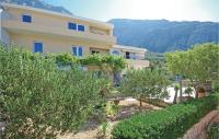 a large building with trees in front of it at Cozy Home In Makarska With Kitchen in Makarska