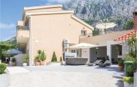 a house with a patio with a mountain in the background at Cozy Home In Makarska With Kitchen in Makarska