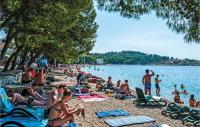 a large group of people sitting on a beach at Cozy Home In Makarska With Kitchen in Makarska