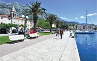 a couple of people walking down a sidewalk next to a canal at Cozy Home In Makarska With Kitchen in Makarska