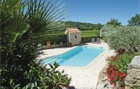 a swimming pool in a garden with a stone house at Awesome Home In Fontarches With 2 Bedrooms, Wifi And Outdoor Swimming Pool in Fontarèches
