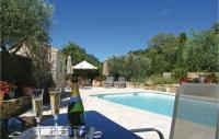 a bottle of champagne and glasses on a table next to a swimming pool at Awesome Home In Fontarches With 2 Bedrooms, Wifi And Outdoor Swimming Pool in Fontarèches