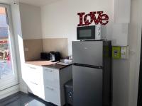 a kitchen with a refrigerator and a microwave on top of it at Appartements VIZILLE GRENOBLE - Route Napoleon in Vizille