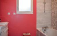 Baño rojo con bañera blanca y lavamanos en 3 Bedroom Beautiful Home In Matignon, en Matignon