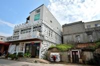 a white building with a balcony on the side of it at Ding Ding Homestay in Jinhu