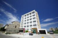 Un edificio alto y blanco en una calle de la ciudad. en Penghu An-I Hotel, en Magong