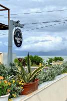 拉斯特拉纳斯La Dolce Vita Beachfront Apt 2的杆子上挂着一个钟，窗台上摆放着植物。