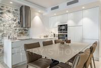 a kitchen with white cabinets and a table and chairs at Paula by Terry&#39;s Homes in Cannes