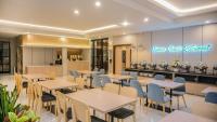 un ristorante con tavoli e sedie e una cucina di Front One King Hotel Tuban a Tuban
