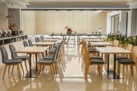una fila di tavoli e sedie in un ristorante di Front One King Hotel Tuban a Tuban