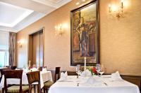 un restaurante con mesas y sillas blancas y una pintura en la pared en Schwarzer Bär Jena, en Jena